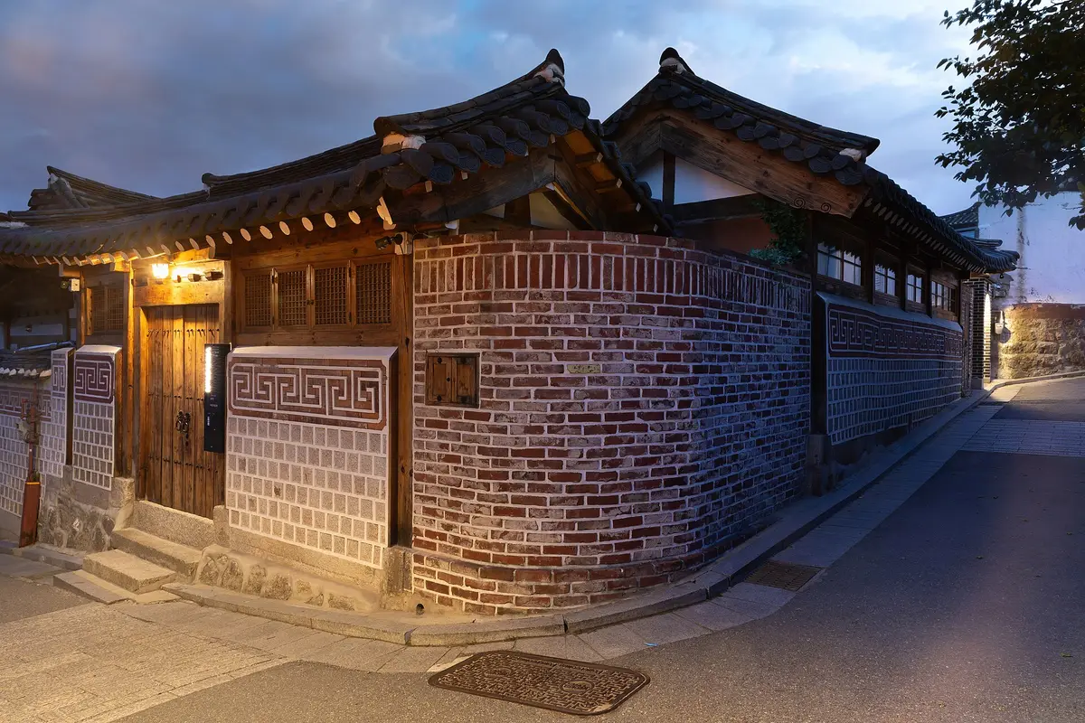 A hanok house in Bukchon at blue hour with its lamps lit