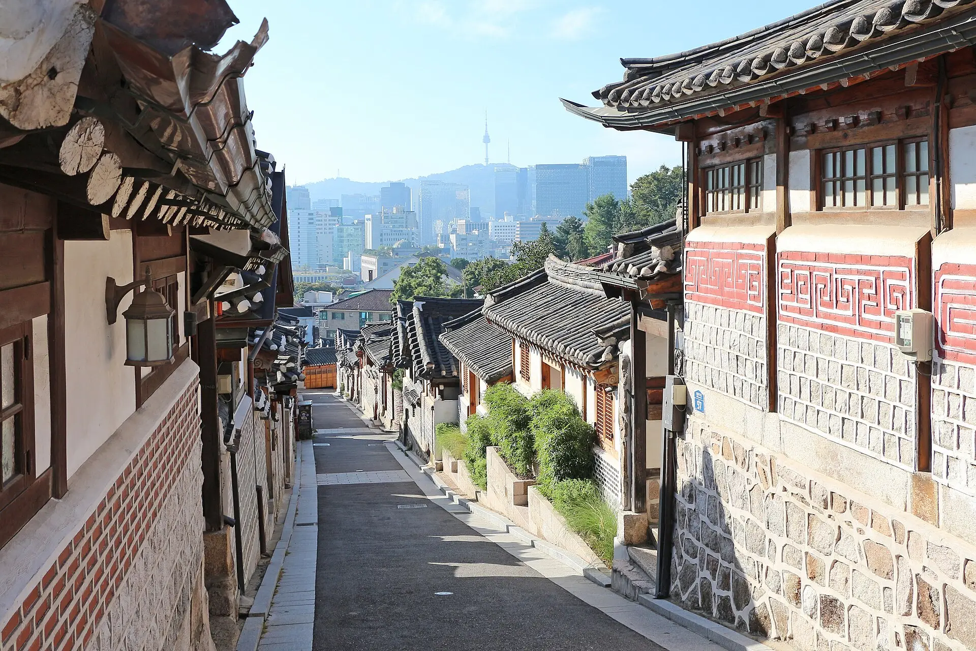 A lane of hanok houses in Bukchon with N Seoul Tower in the distance